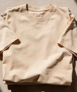 Close-up image of a beige unisex oversized t-shirt showing the fabric texture and color details.