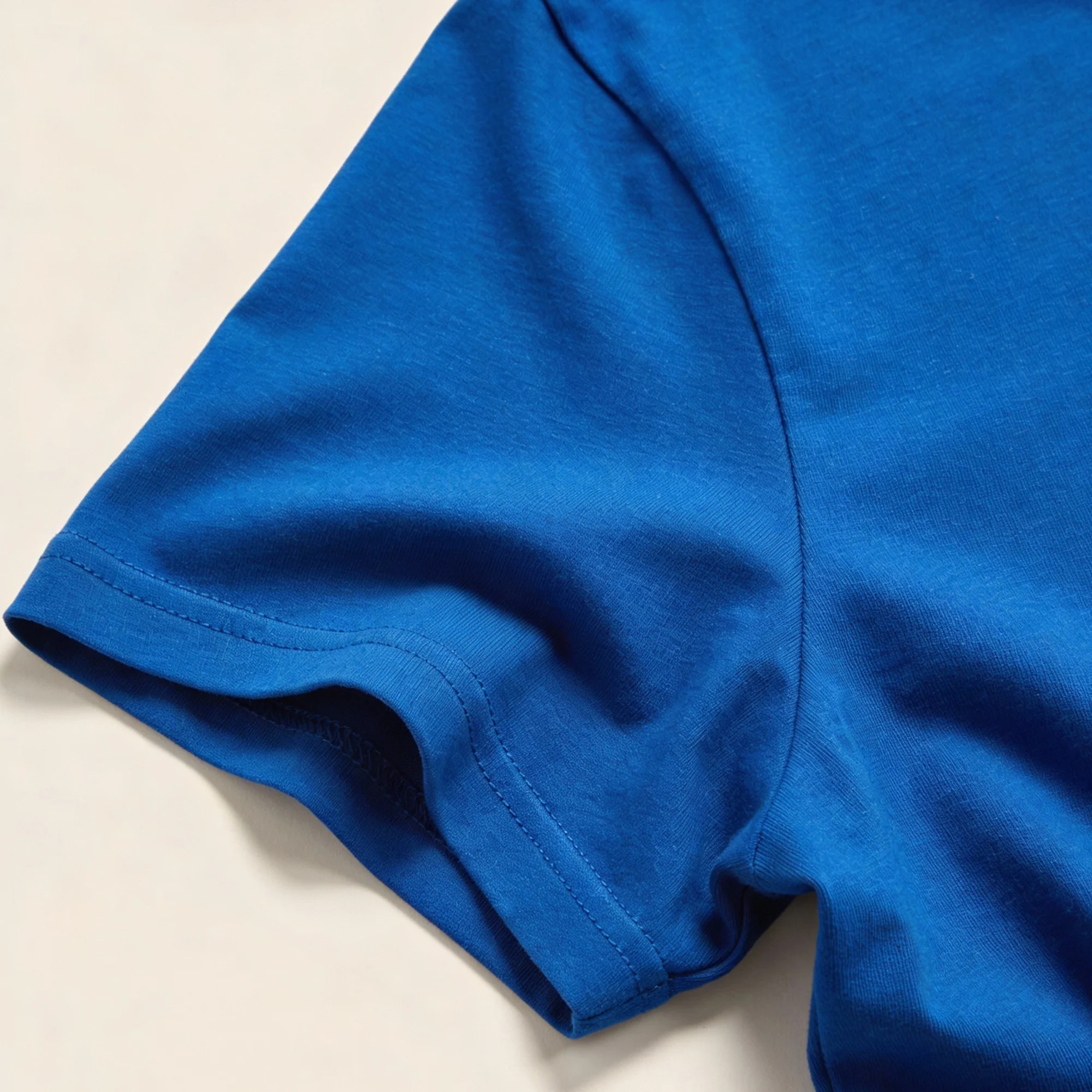 Close-up photo of a royal blue unisex t-shirt showing the fabric texture, stitching, and true color.