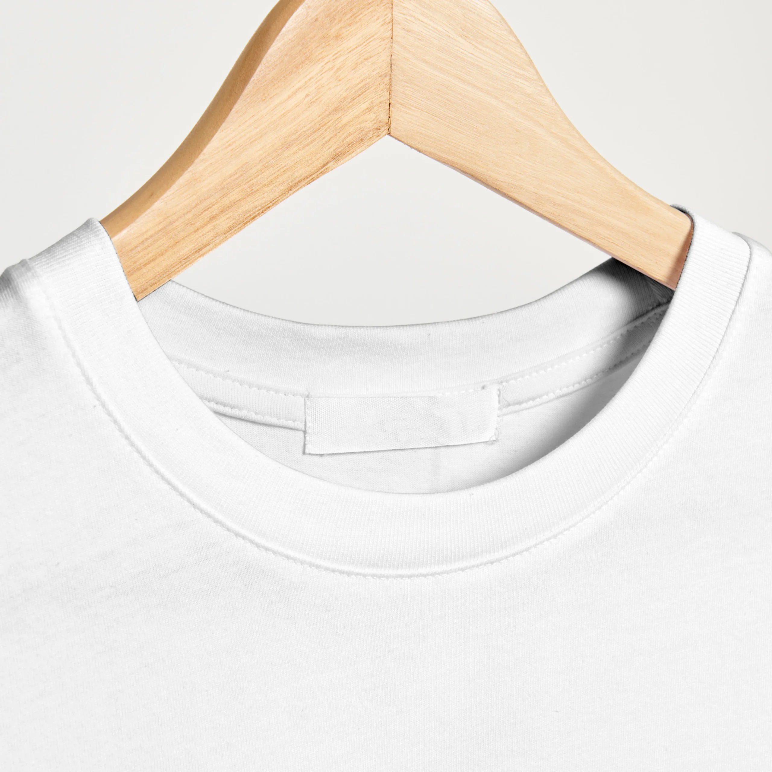 Close-up view of the neck pattern on a white oversized T-shirt.