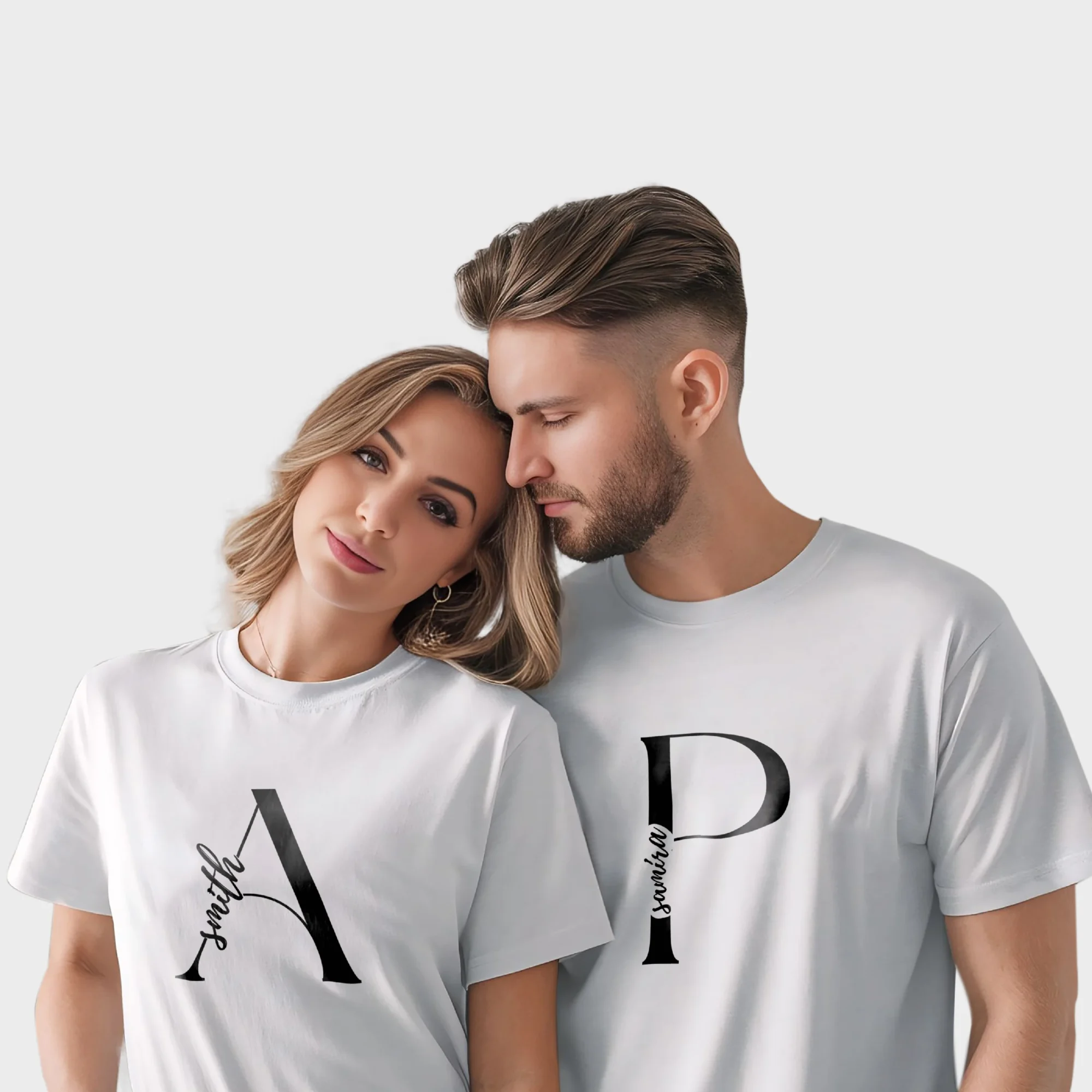 Couple wearing personalized matching white t-shirts with custom names printed on premium cotton fabric, ideal for pre-wedding photoshoots and anniversary gifting.