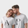 Couple wearing personalized matching white t-shirts with custom names printed on premium cotton fabric, ideal for pre-wedding photoshoots and anniversary gifting.